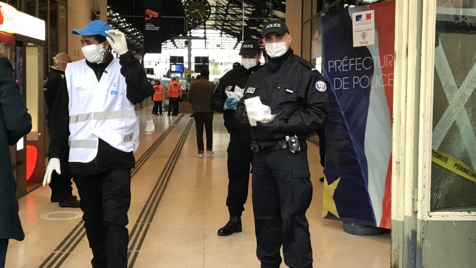 Vid Gare de Lyon, en av den franska huvudstadens fem tågstationer, hjälper poliser till att dela ut munskydd till alla.