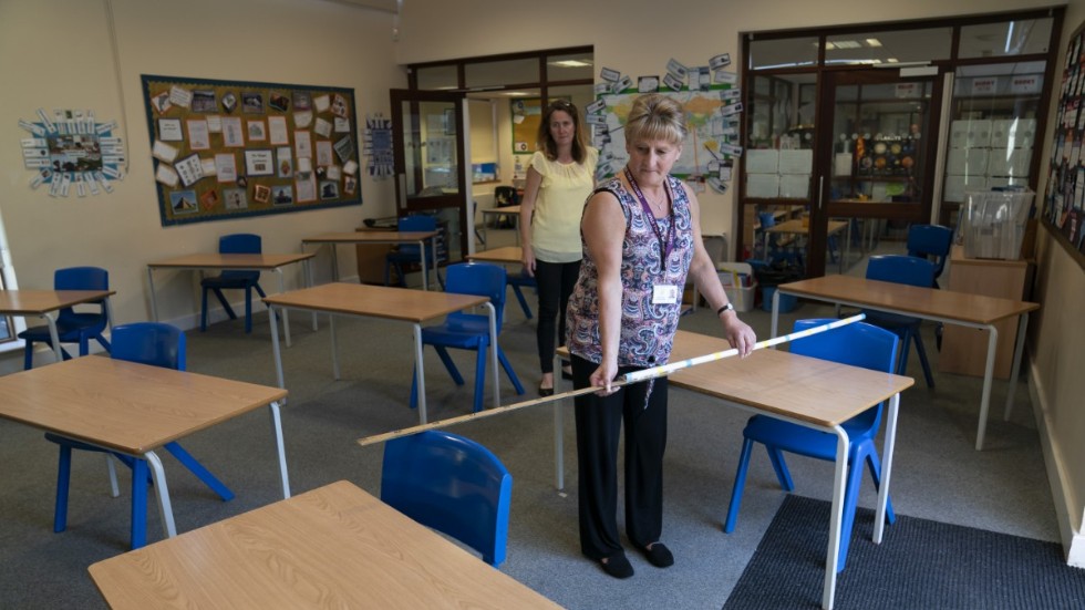 Jane Cooper, lärare i sjätte klass, kontrollerar avståndet mellan skolbänkarna i sitt klassrum i skolan Lostock Hall i Poynton i närheten av Manchester.