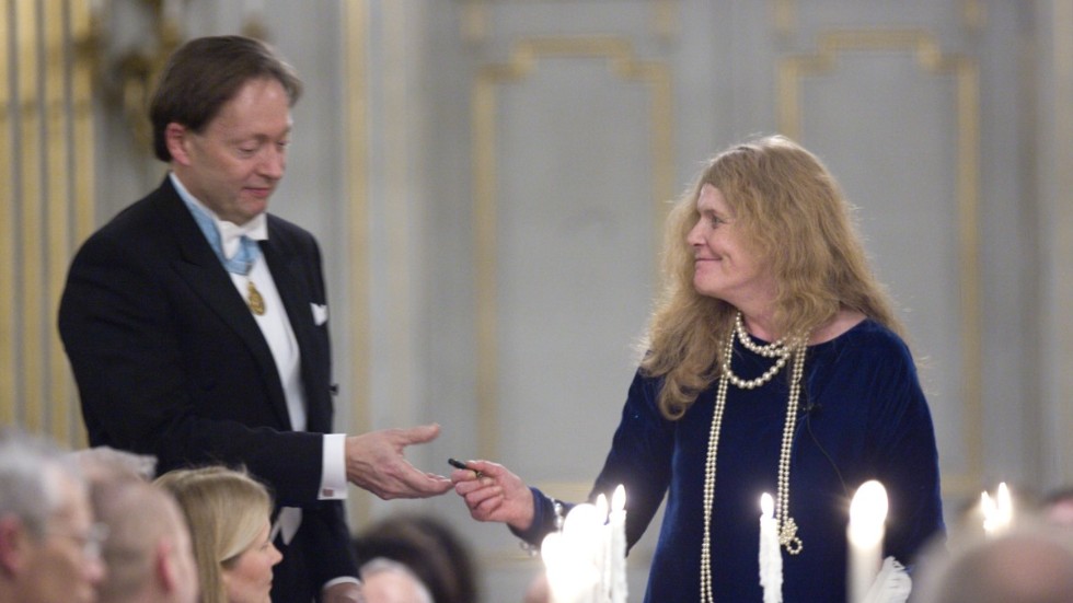 Kristina Lugn lämnar pennan till ständige sekreteraren Horace Engdahl sedan hon skrivit på som ny ledamot av Svenska Akademien, under akademiens högtidssammankomst i Stockholm. Bilden är från den 20 december 2006.