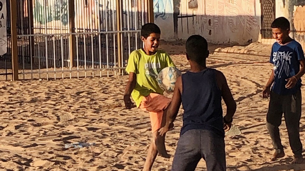 Västsahariska barn som spelar fotboll mellan husen i ett av de flyktingläger som funnits så länge att många av dem som bor där aldrig sett något annat.