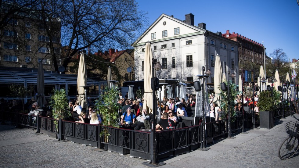 Folk sitter på uteserveringar på Medborgarplatsen i Stockholm trots covid-19-pandemin. Arkivbild.