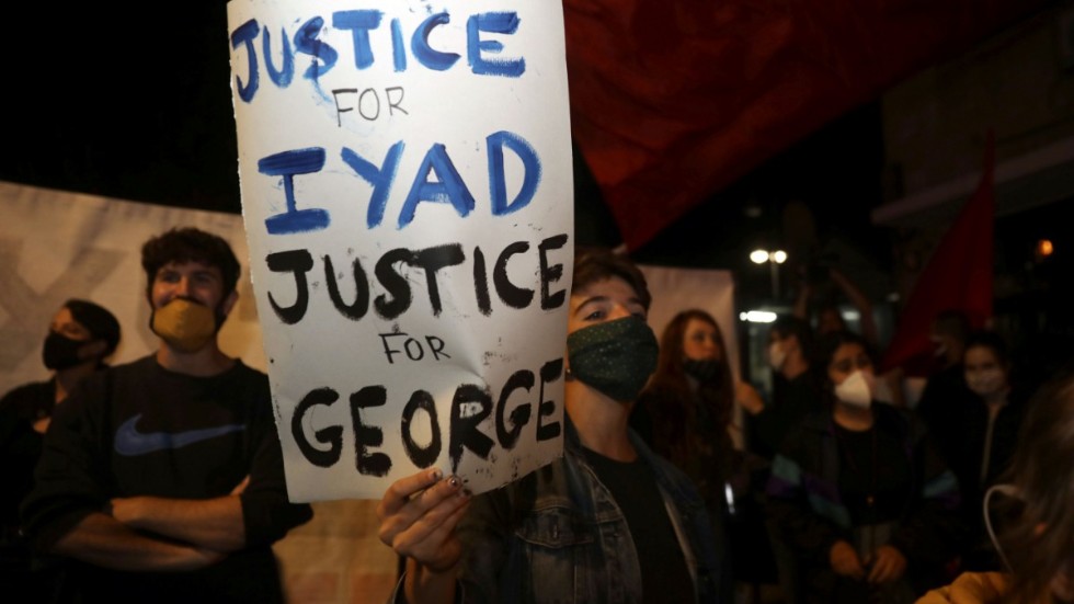 Demonstranter i Jerusalems gamla stadskärna håller upp plakat som kräver rättvisa för Iyad Halak och George Floyd. Bilden är från den 30 maj, samma dag som Halak sköts ihjäl.