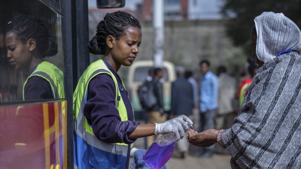 En volontär erbjuder handdesinfektion till kollektivtrafikpassagerare i den etiopiska huvudstaden Addis Abeba. Arkivbild.