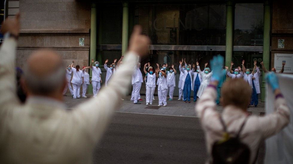 Spanska vårdarbetare hyllades utanför ett sjukhus i Barcelona i tisdags.