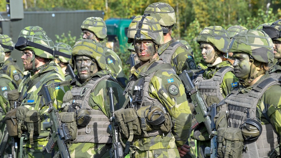 Soldater med kamouflagemålning under försvarsövningen Aurora 17. Arkivbild.