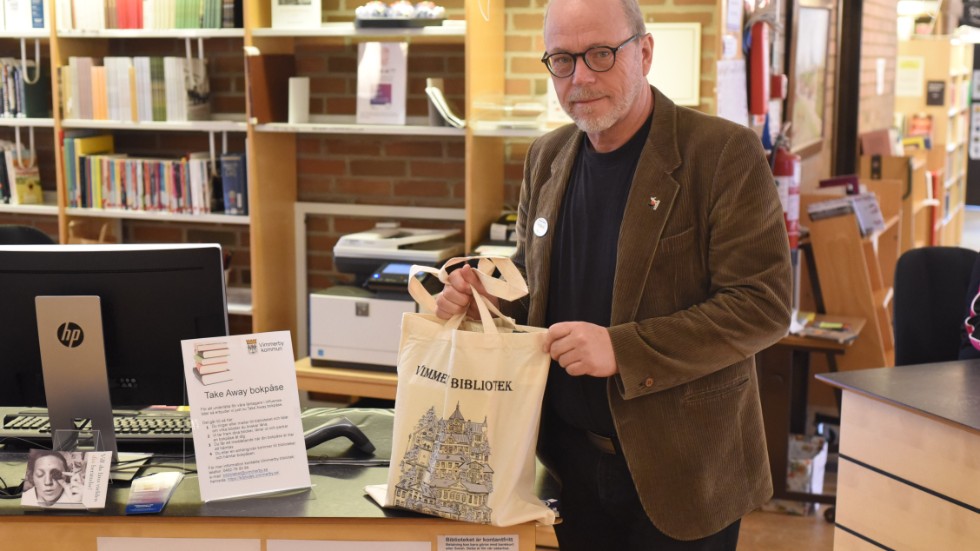 Thomas C Eriksson bibliotekschef på Vimmerby kommun med en take away-bokpåse som man börjat att erbjuda i dagarna.