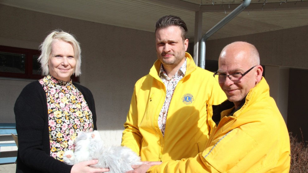 Här får Kinda kommun, genom Pernilla Arvidsson, ta emot gåvan i form av robotkatter från Lionsrepresentanterna Anders H Bouvin och Jörgen Banck.