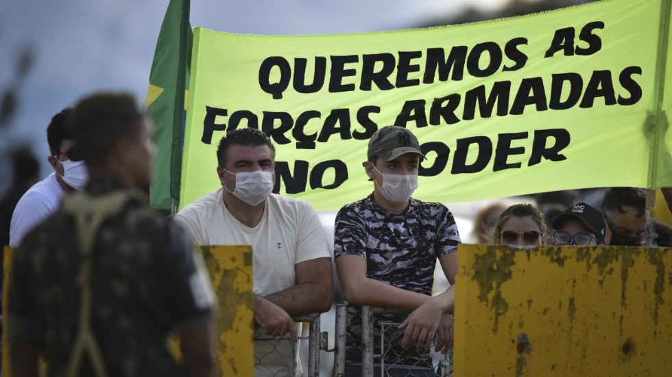 Demonstranter med en banderoll med budskapet "Vi vill se armén vid makten" under söndagens manifestation i Brasília.