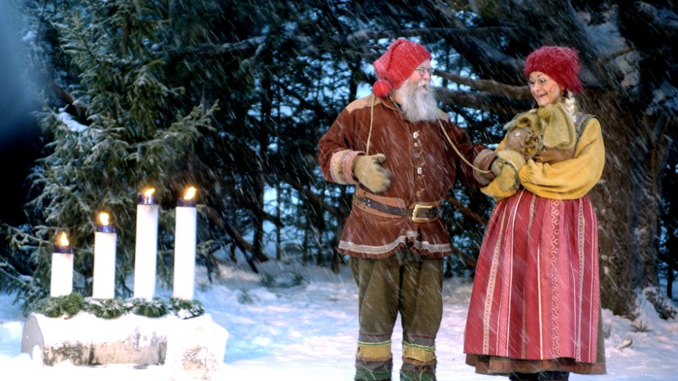 Tomtefar och tomtemor framför adventsljusstaken, julkalendern 2003 i stadsparken. Rollerna spelades då av Harry Nyman och Helena Anderholm.