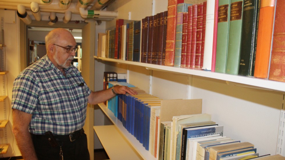 Ingvar Belkert kollar in en del av den omfattande boksamlingen hos släktforskarföreningen.