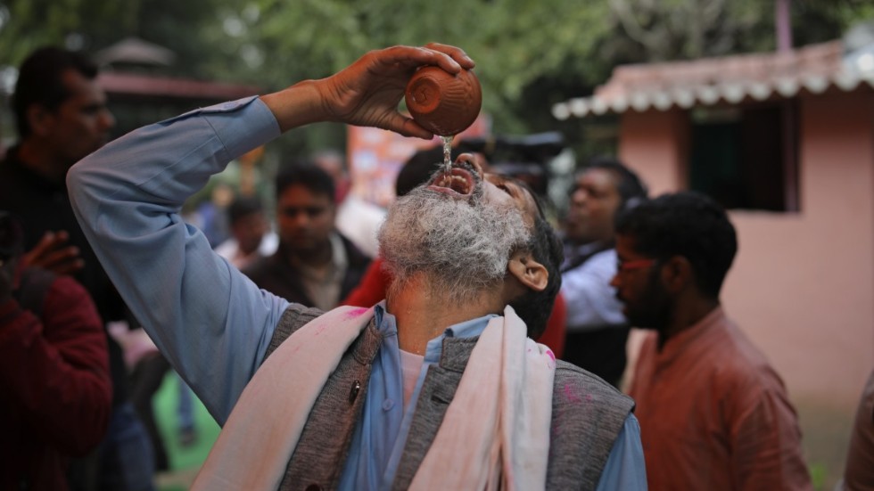 En man indisk dricker gaumutra, eller urin från kor, under ett evenemang i New Delhi i mars.