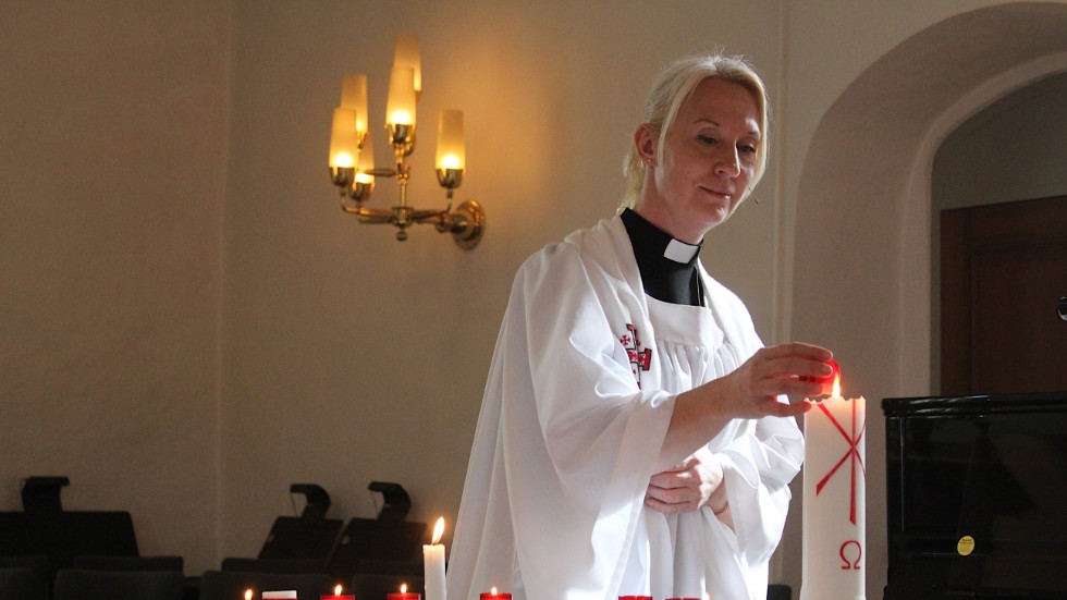 Kyrkoherde Anita Waernqvist tänder ljus. Istället för körsång och önskepsalmer blev det enkel gudstjänst med fokus på bön och ljuständning i Södra Vi kyrka på söndagen.
