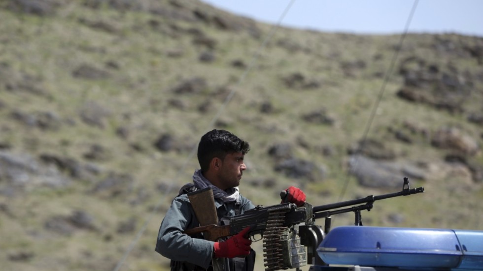 En afghansk polis håller vakt vid en plats där en självmordsattack genomförts utanför Afghanistans huvudstad Kabul.