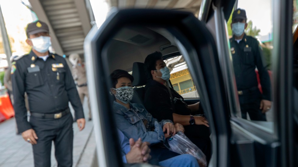 En polis stannar ett fordon i Bangkok för att kontrollera att förare och passagerare inte har feber.