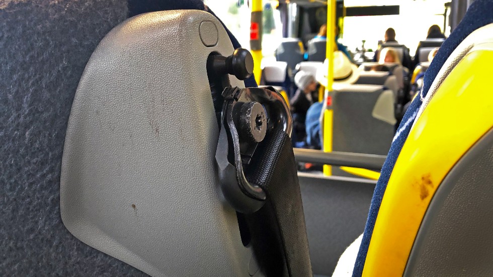 Där bältet är fastskruvat i stolen ska det sitta en plastkåpa på en del av bussarna. Det är vanligt förekommande att dessa slits sönder, precis som det har gjorts här.
