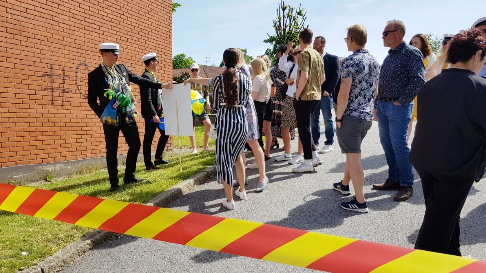 Utanför den avspärrade skolgården vid gymnasiet väntade ytterligare gratulanter på sina studenter.