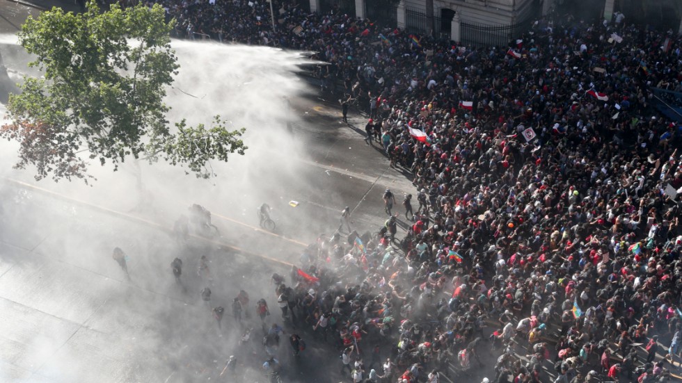 Polisen i Chile vattenbombar demonstranterna för att skingra folkmassan. 