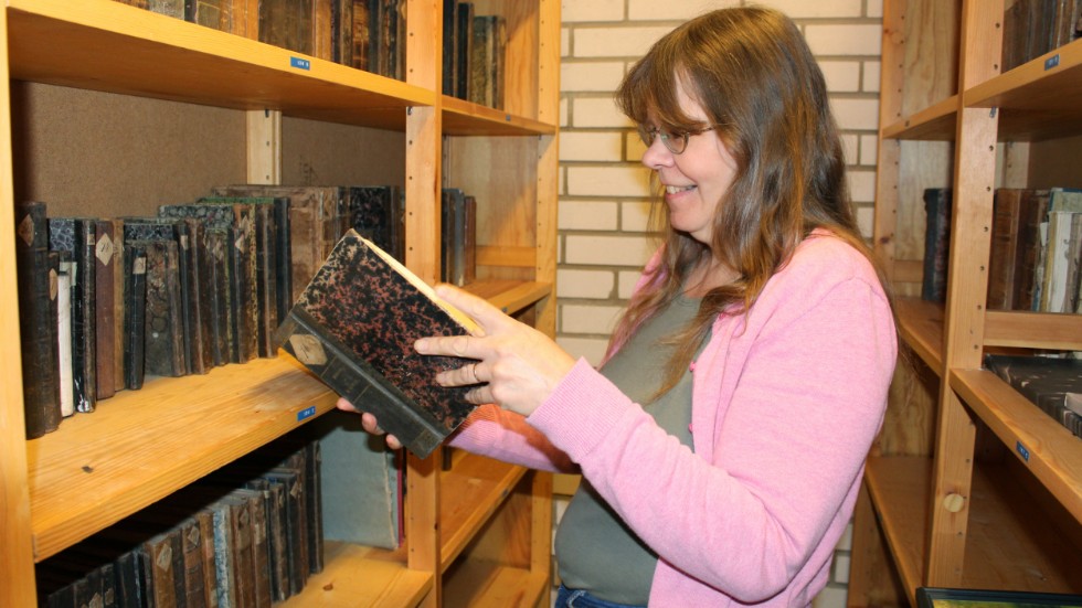 Ulla-Karin Karlsson som arbetar i kommunens arkiv gläds åt det senaste tillskottet i gömmorna - gamla fina böcker från Folkströms skolbibliotek.