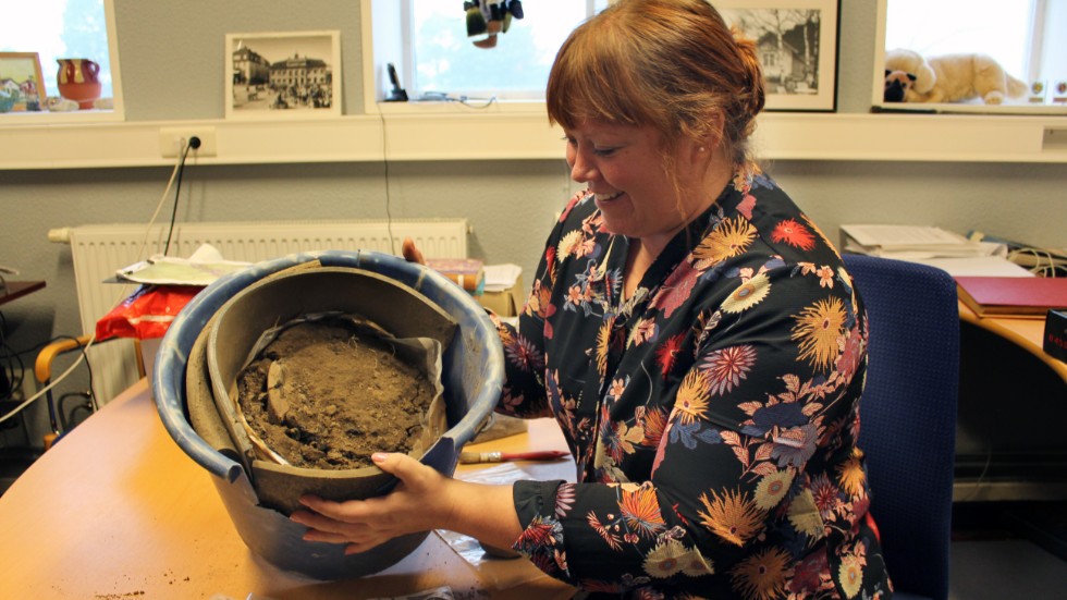 Veronica Palm visar kärlet som hon hittade vid utgrävningen i Dvärgstad.