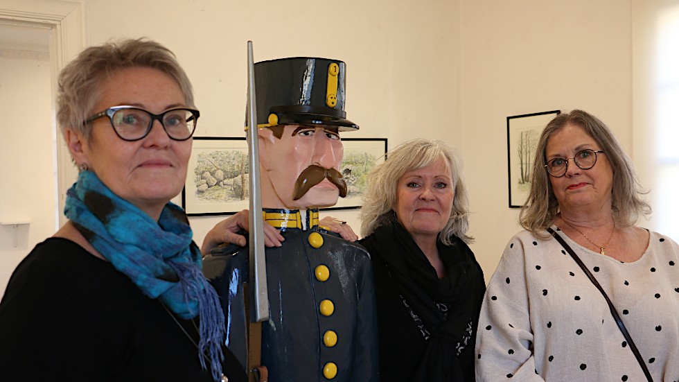 Lisa Sköld, Rose Hägg och Monika Larsson, syskonbarn till konstnären, tillsammans med knekten som vakar över utställningen.