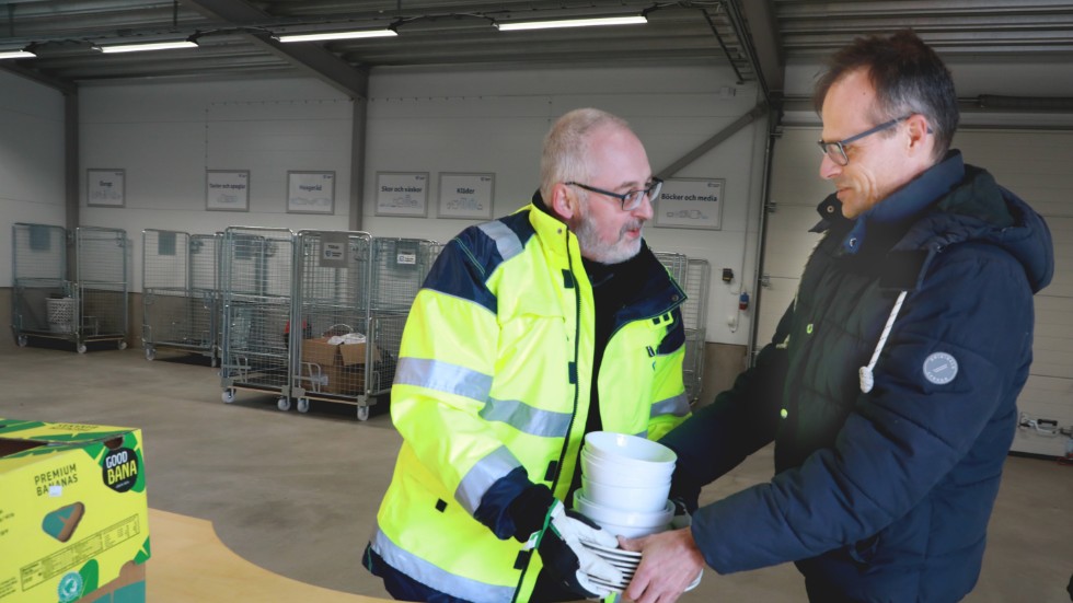 Michael Skog tar emot Björn Löwgrens porslin i återbrukshallen på Malmens återvinningscentral.  
