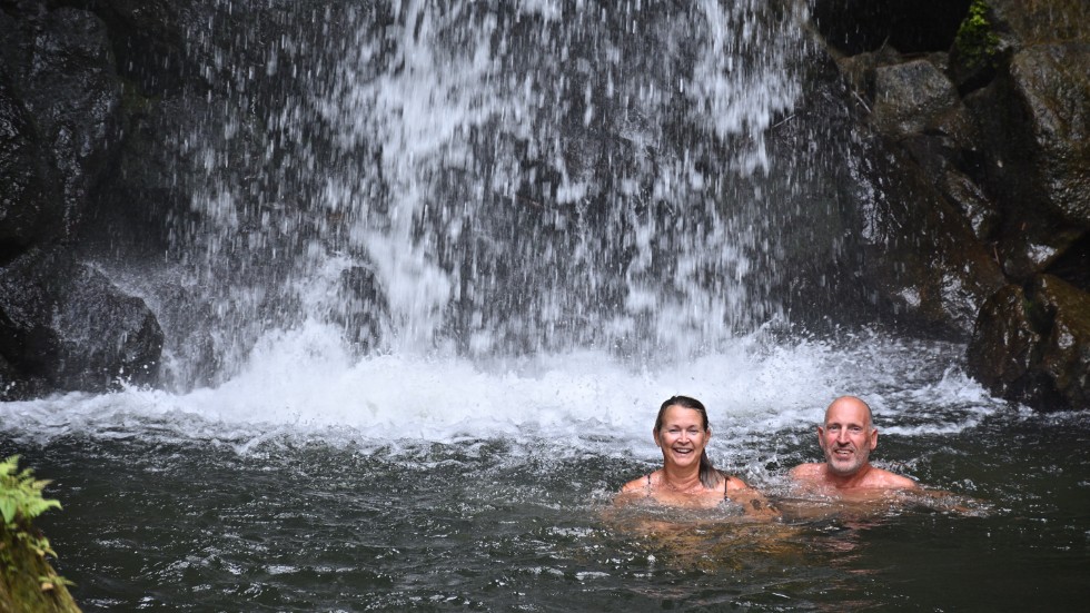 Anki och Sivert svalkar sig i ett vattenfall på ön Dominica.