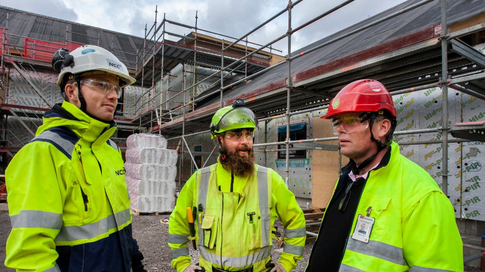 Fredrik Pettersson, Krister Svensson och Magnus Cato samtalar vid byggarbetsplatsen vid Svärtinge skogsbacke.