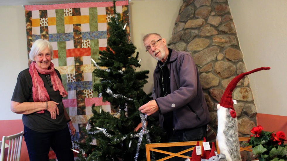 Kristina och Johnny Jonsson pyntar plastgranen inför julmarknaden. I förgrunden några lotterivinster.