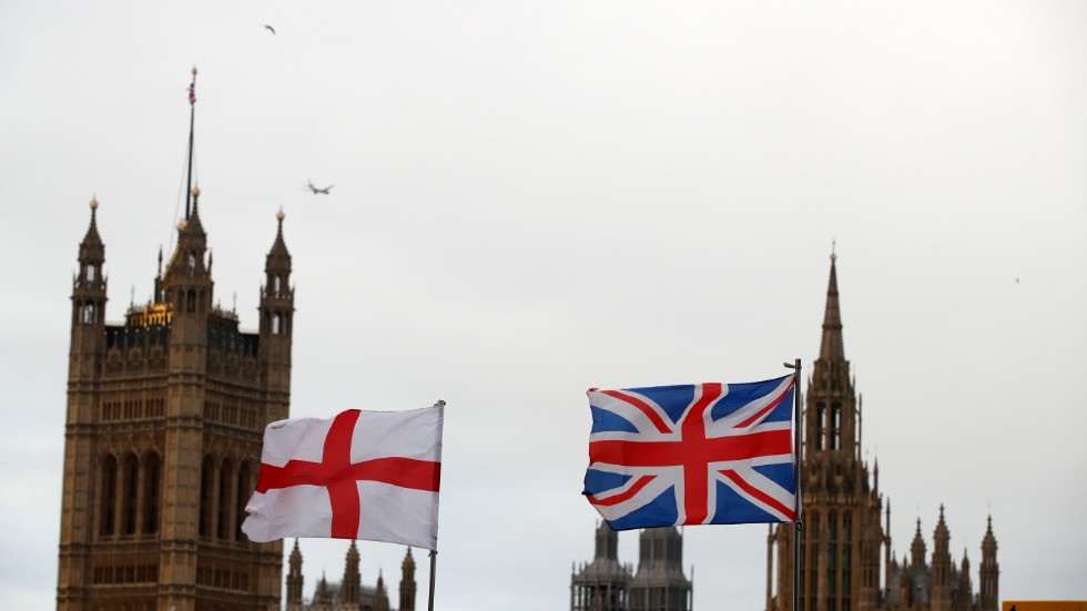 Englands och Storbritanniens flagga vajar sida vid sida utanför parlamentet. Nu kritiserar skribenten det brittiska valsystemet, som han menar inte ger en representativ bild av det verkliga valresultatet.