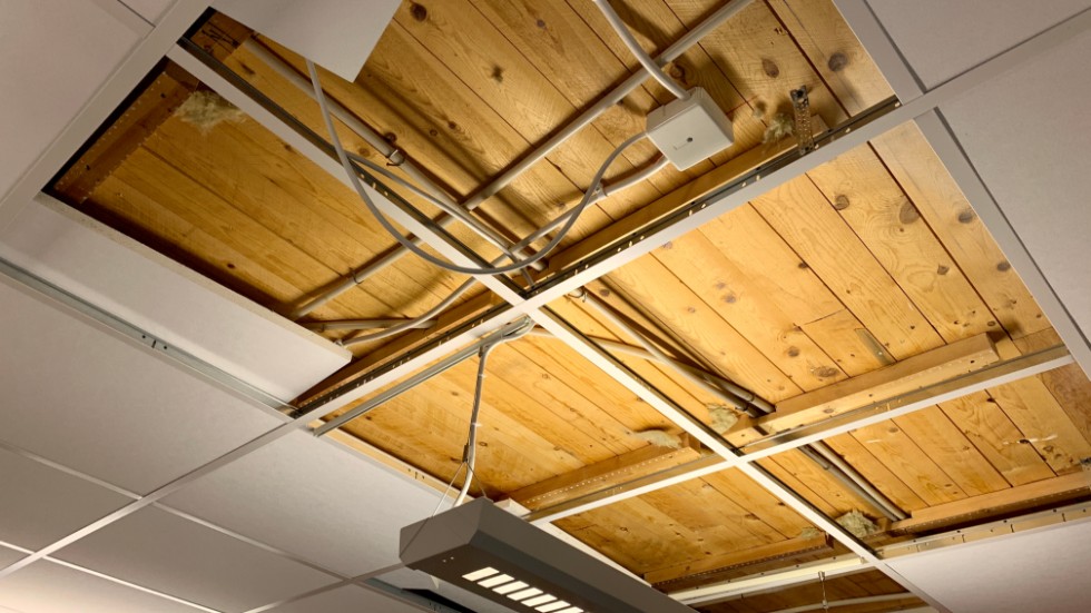 En bit av taket i ett klassrum har rivits bort för att undersöka storleken på skadan där det droppat in vatten.