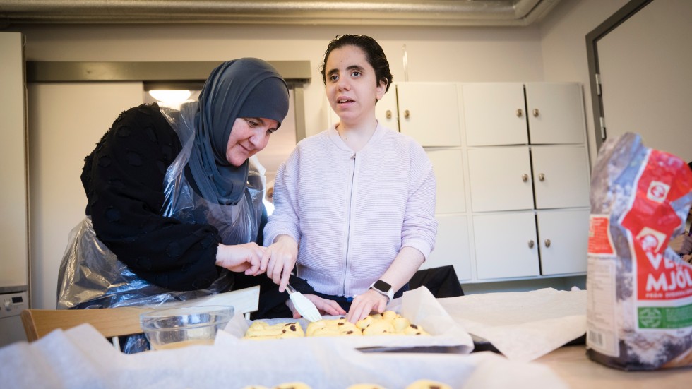 Saida Alshaebe visar Majad Aydi hur man penslar ägg på saffransbullar. Tidigare i veckan har de bakat olika sorters kakor, desserter och lagat mat. 