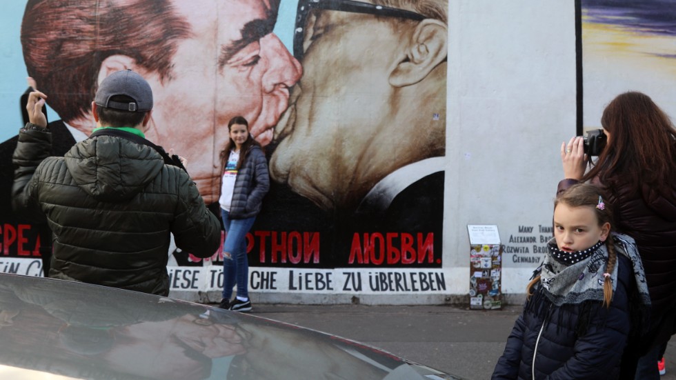 Kommunistisk kyss på den bevarade del av muren nära Warschauer strasse. Kö när turisterna ska fotografera varandra framför kyssen.