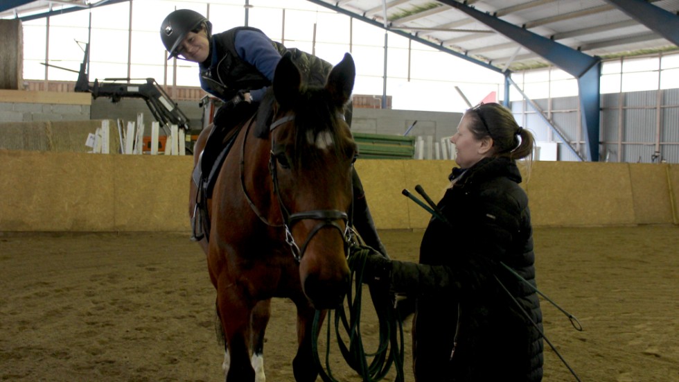 Anna-Corinne visar hur det ser ut när man "hänger" på en häst. Det gör man för att vänja unghästen vid att ha något på ryggen. 