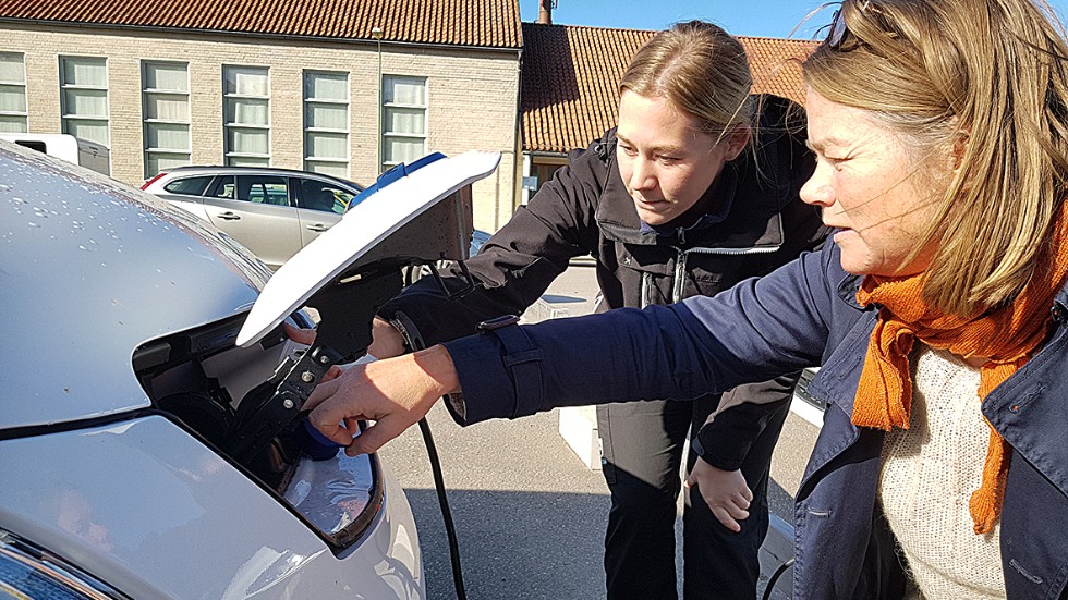 Cecilia Ledström, arbetsterapeut i Vadstena, och Energikontorets Ylva Ek, kollar laddningen på den el-skåpbil som kommunen ska testköra den kommande veckan. 