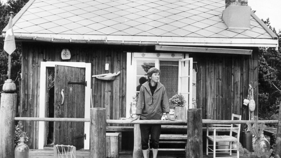 Tove Jansson hade flera hus på ön Bredskär i Finska Viken. Här står hon 1961 på verandan till ett av sina Muminhus, "Vindrosens hus" som hon själv byggde, en tillgång krönikören Elin Ruuth gärna haft.