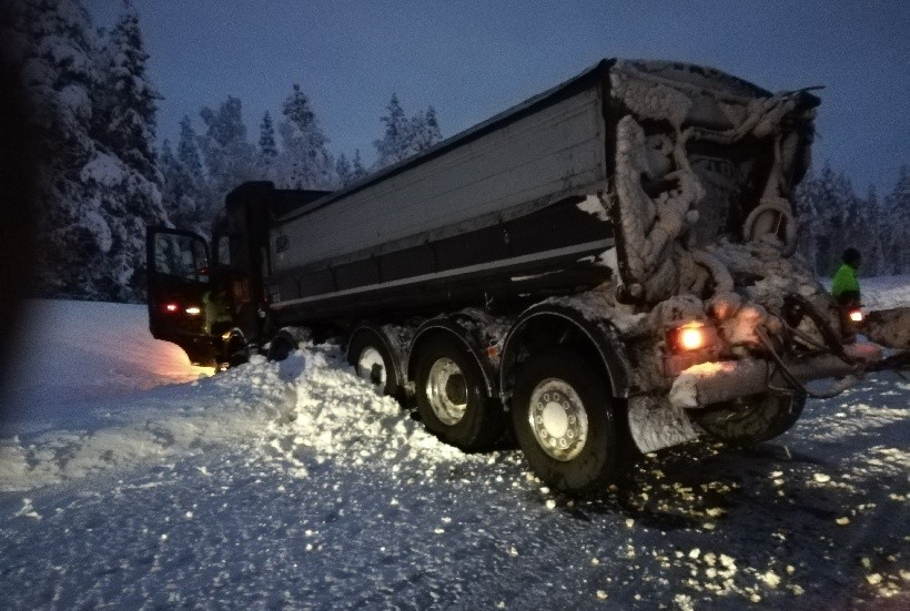 Malmlastbilen har glidit av vägen och begravts i det snöfyllda diket.