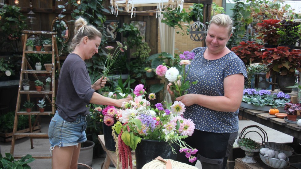 Hannah Dahlholm och floristen Caroline Kraft
tar hand om ett par hinkar med sommarblommor.
