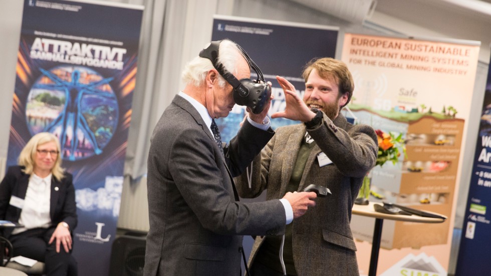 Tobias Bauer, biträdande professor, visar kungen hur han ska använda VR-glasögonen. 