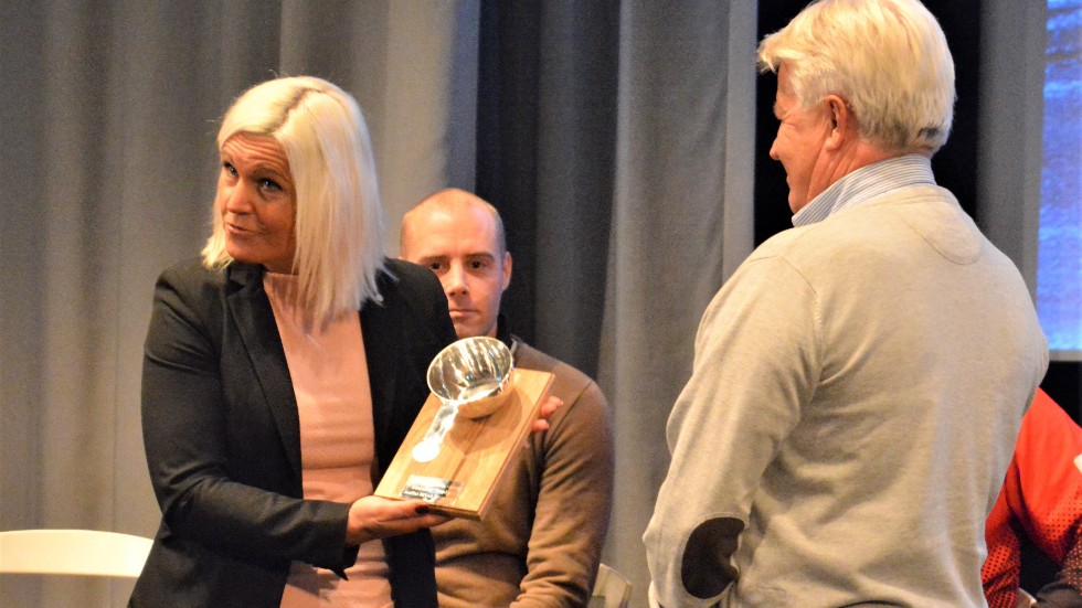 Marie Svensson överräcker damkåsan i äkta silver till C-G Larzon från SMK:s centralstyrelse. I bakgrunden syns kåsans presschef Johan Nordin som jobbat hårt för instiftandet av priset.
