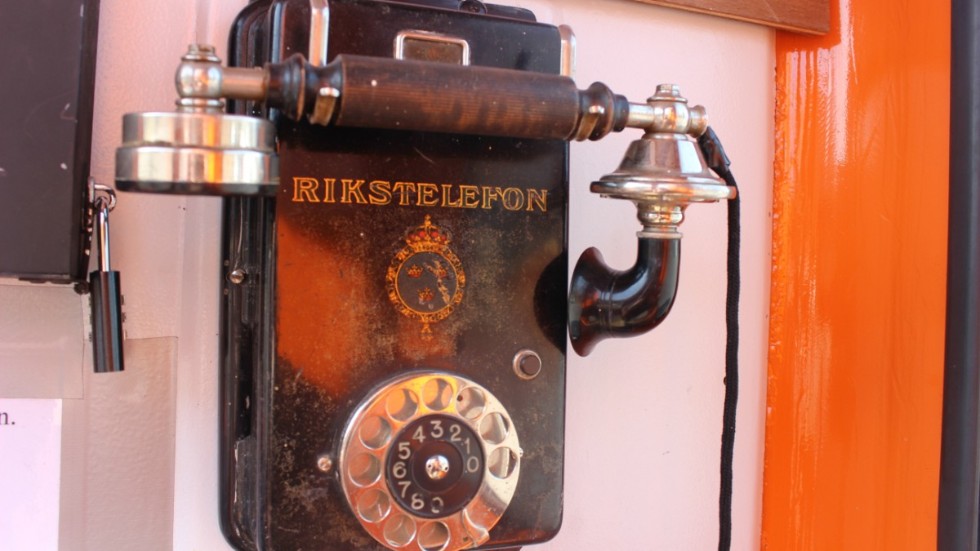 Gammal klassisk telefon syns inne i kiosken.