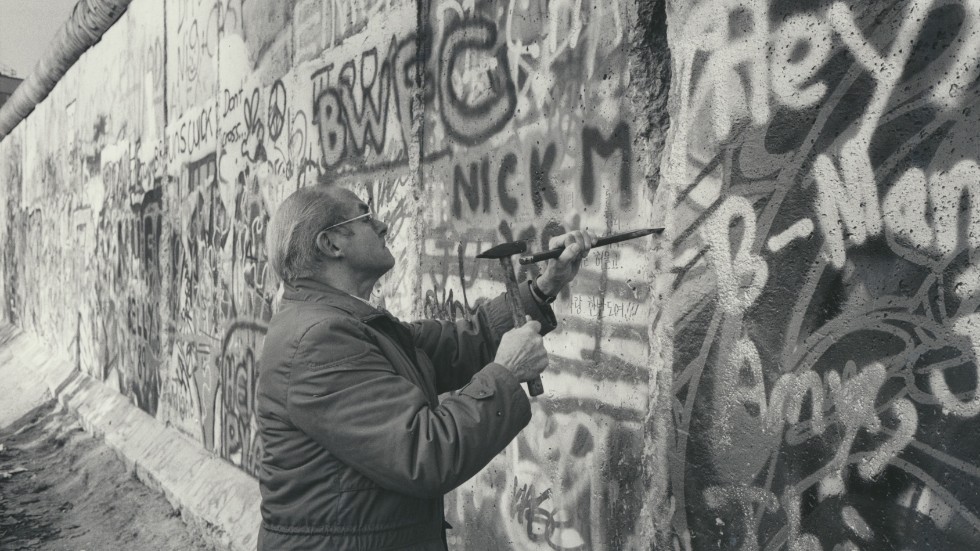 En vanlig syn dagarna efter att Berlinmuren öppnats i november 1989. Berlinare på båda sidor kommer utrustade med hammare och spett för att knacka loss en bit av den förhatliga muren.