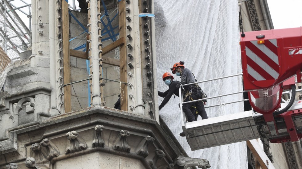 Arbetare lyftes upp till Notre-Dame för att inleda arbetet med att avlägsna de smälta byggnadsställningarna under måndagen.