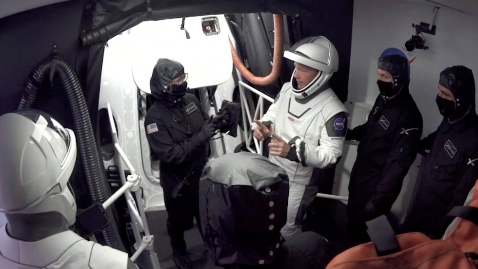 Astronauterna Doug Hurley och Bob Behnken lämnar kapseln Crew Dragon efter onsdagens avbrutna försök att skjuta upp raketen.