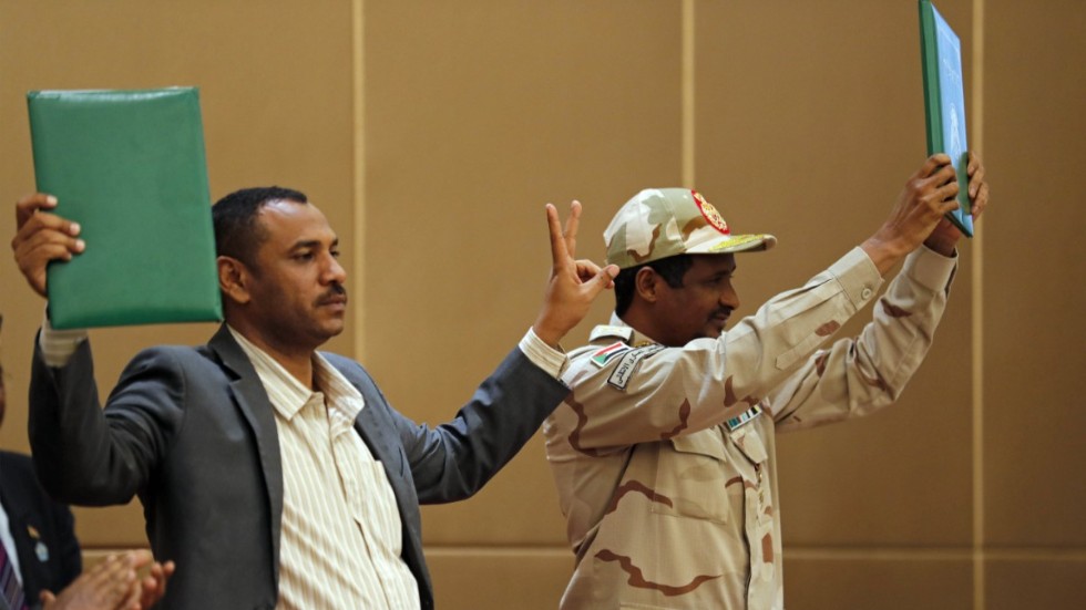 Protestledaren Ahmed Rabie (vänster) och generalen Mohammed Hamdan Dagalo håller upp ett påskrivet avtal om maktdelning i Khartum den 4 augusti förra året.