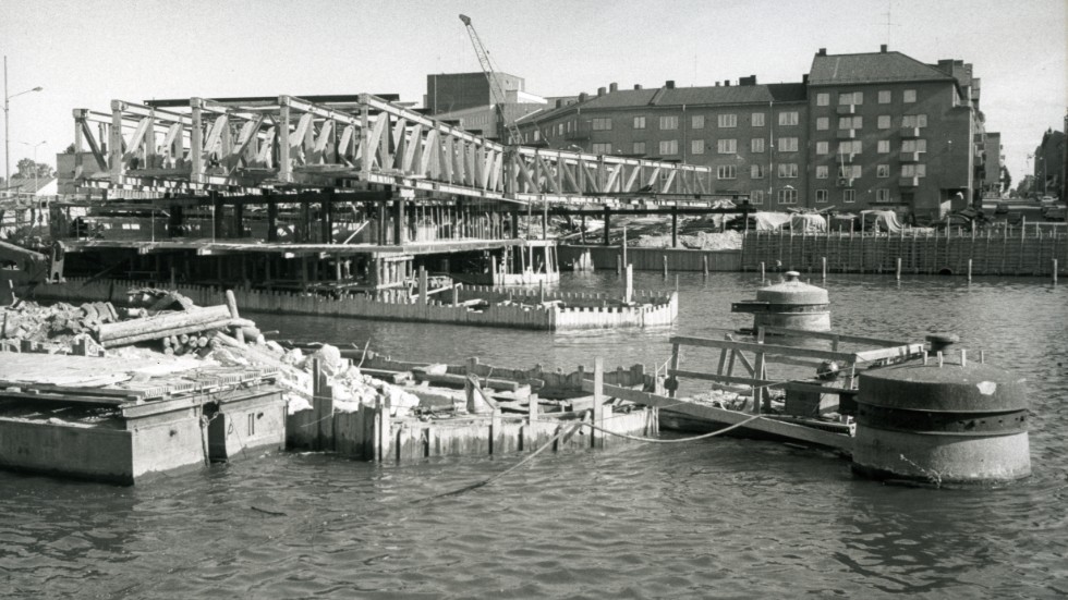 1970. Med ett knappt halvår kvar till trafiken släpps på, är arbetet i full gång med nya Hamnbron. Kopplingen till den ursprungliga bron kan hittas i de gamla brofundamenten som nu kom till fortsatt användning.