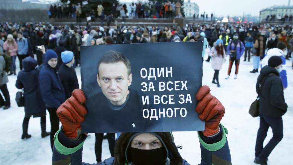 En demonstrant med ett plakat med en bild på den fänglsade oppositionsledaren Aleksej Navalnyj och texten "En för alla, alla för en" under protester i S:t Petersburg i lördags.