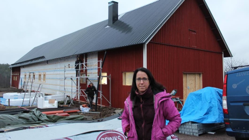 Jennie Norström från styrelsen framför ridskolans stora stall, som nu totalrenoveras.