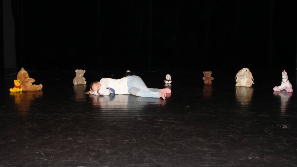 Kristin sover med sina gosedjur i Kulturskolans pjäs om en flicka som får hjälp att bli modig.