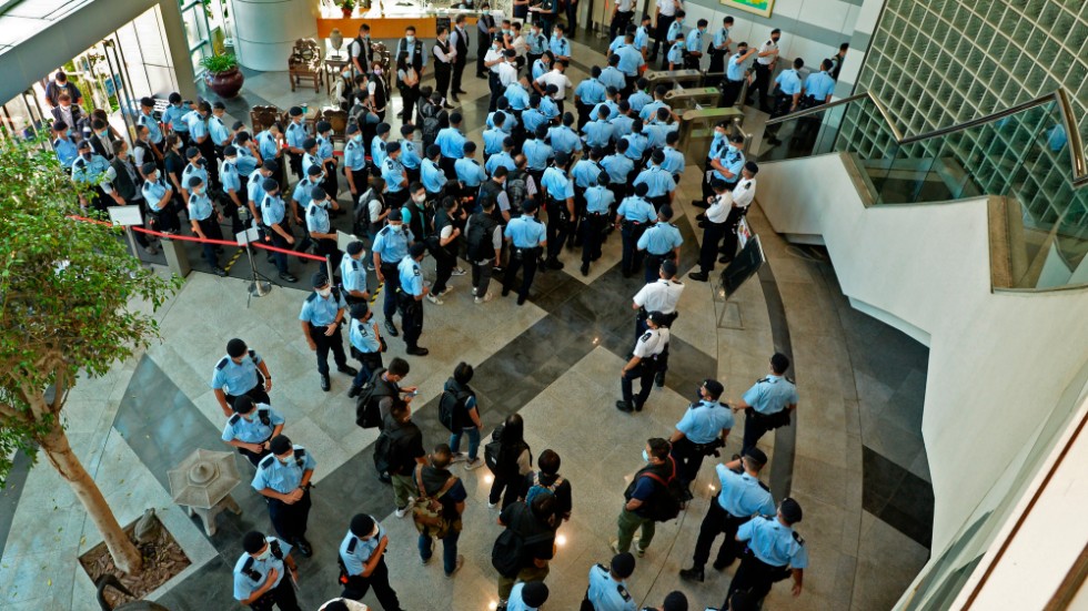 Hundratals poliser gör en räd på den prodemokratiska tidningen Apple Daily i Hong Kong. 