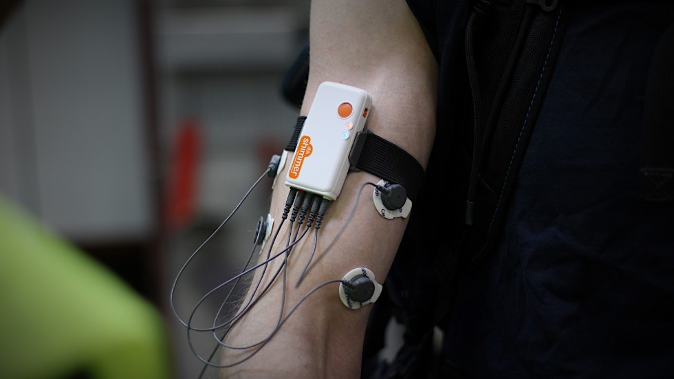 Sensorer och en mätutrustning fästs på Mathias Gustafssons arm. Den ska mäta hur mycket muskelstyrka som krävs när han arbetar med och utan exoskelett. 